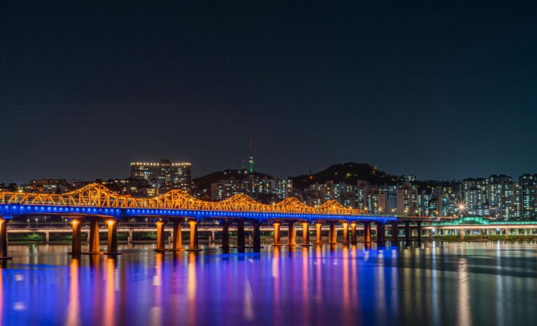 Stunning night view of Seoul skyline with an illuminated bridge over the Han River. Vibrant cityscape.