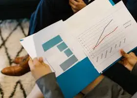 Detailed view of business reports with graphs during a corporate meeting.