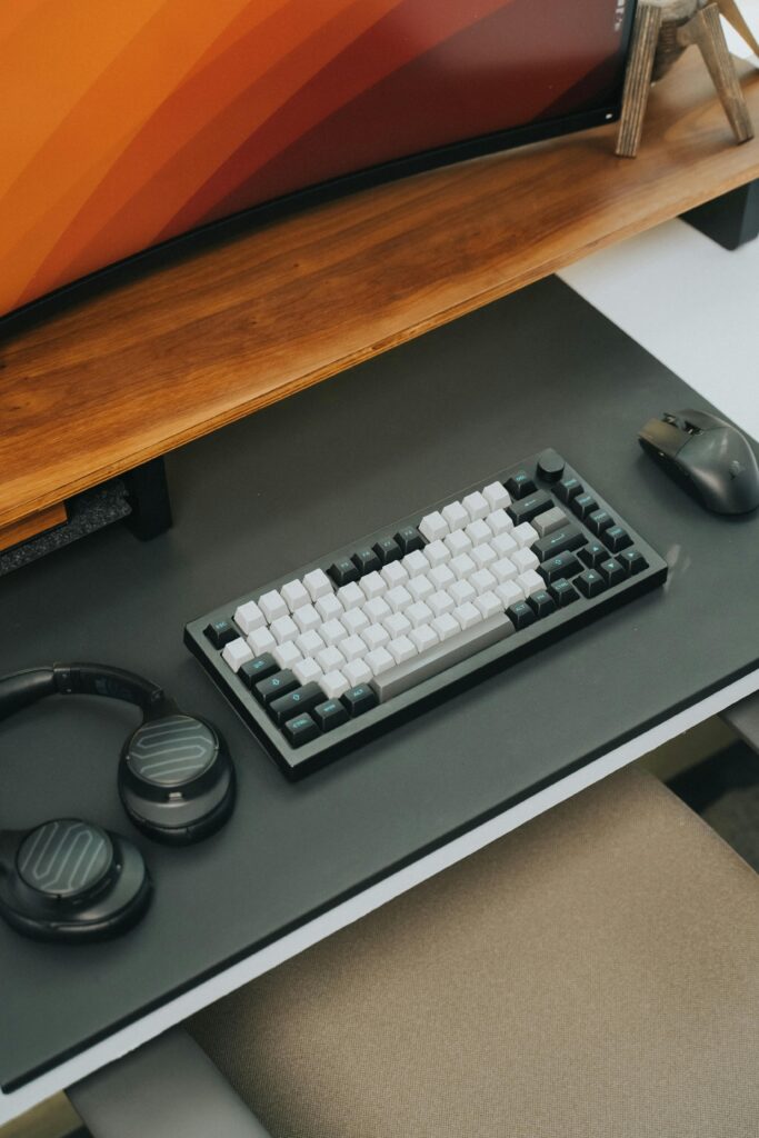 Top view of a modern office desk with keyboard, mouse, and headphones for efficient work.